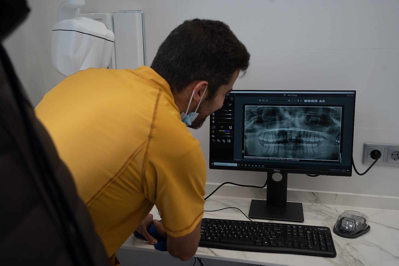 Un odontólogo de Clínica Coliseum revisa en el monitor la radiografía panorámica de un paciente