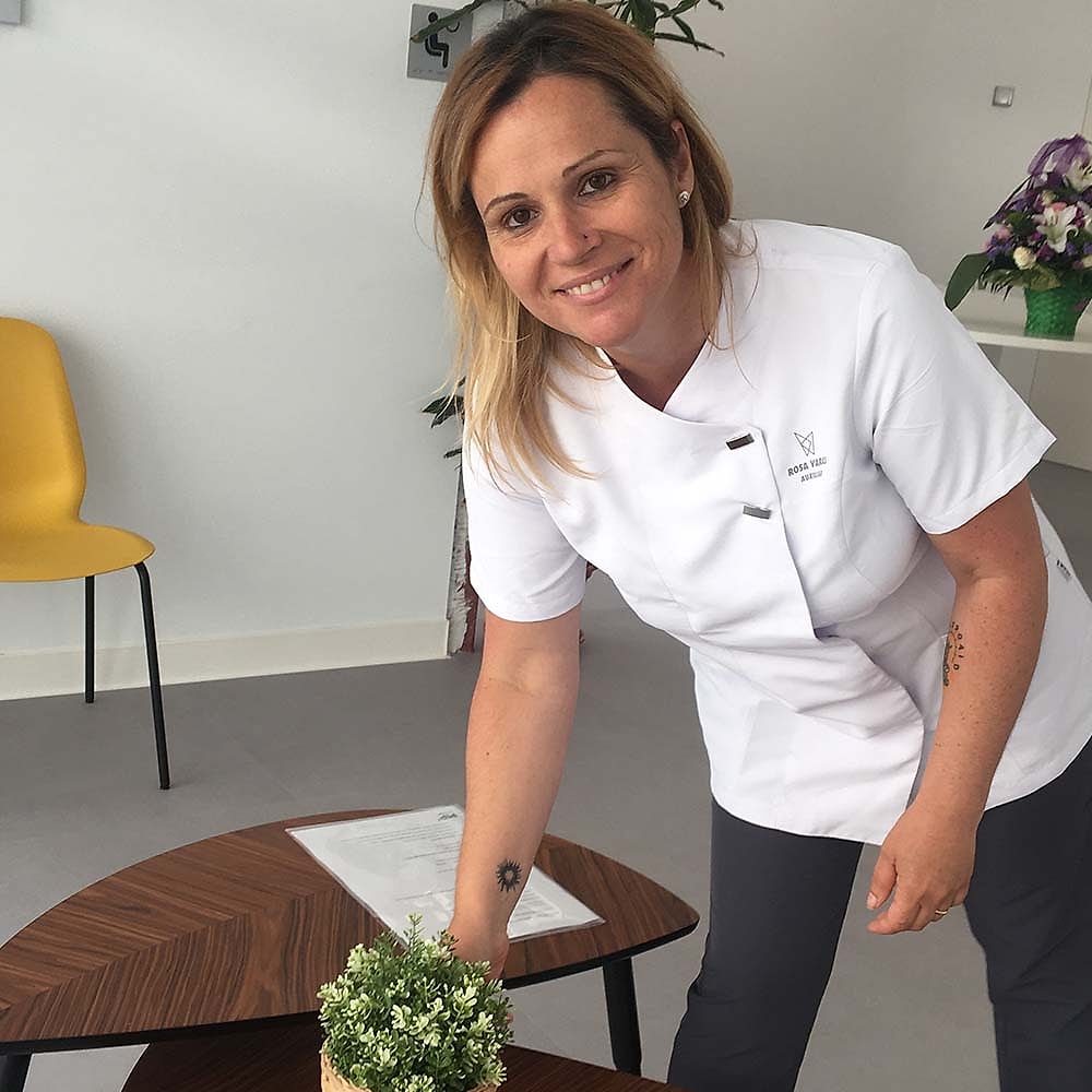 María Rosa Varas, auxiliar de clínica, con el uniforme blanco de Clínica Coliseum en la sala de espera