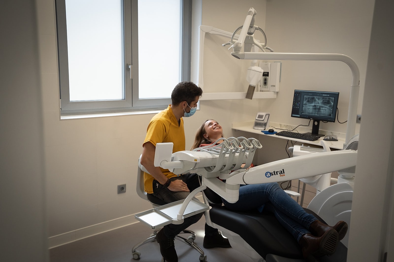 Uno de los gabinetes de Clínica Coliseum, con el sillón dental junto a la ventana y el monitor de diagnóstico